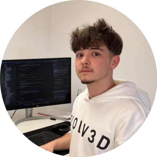 Rostyslav Tulika am Arbeitsplatz vor einem Monitor mit Code
